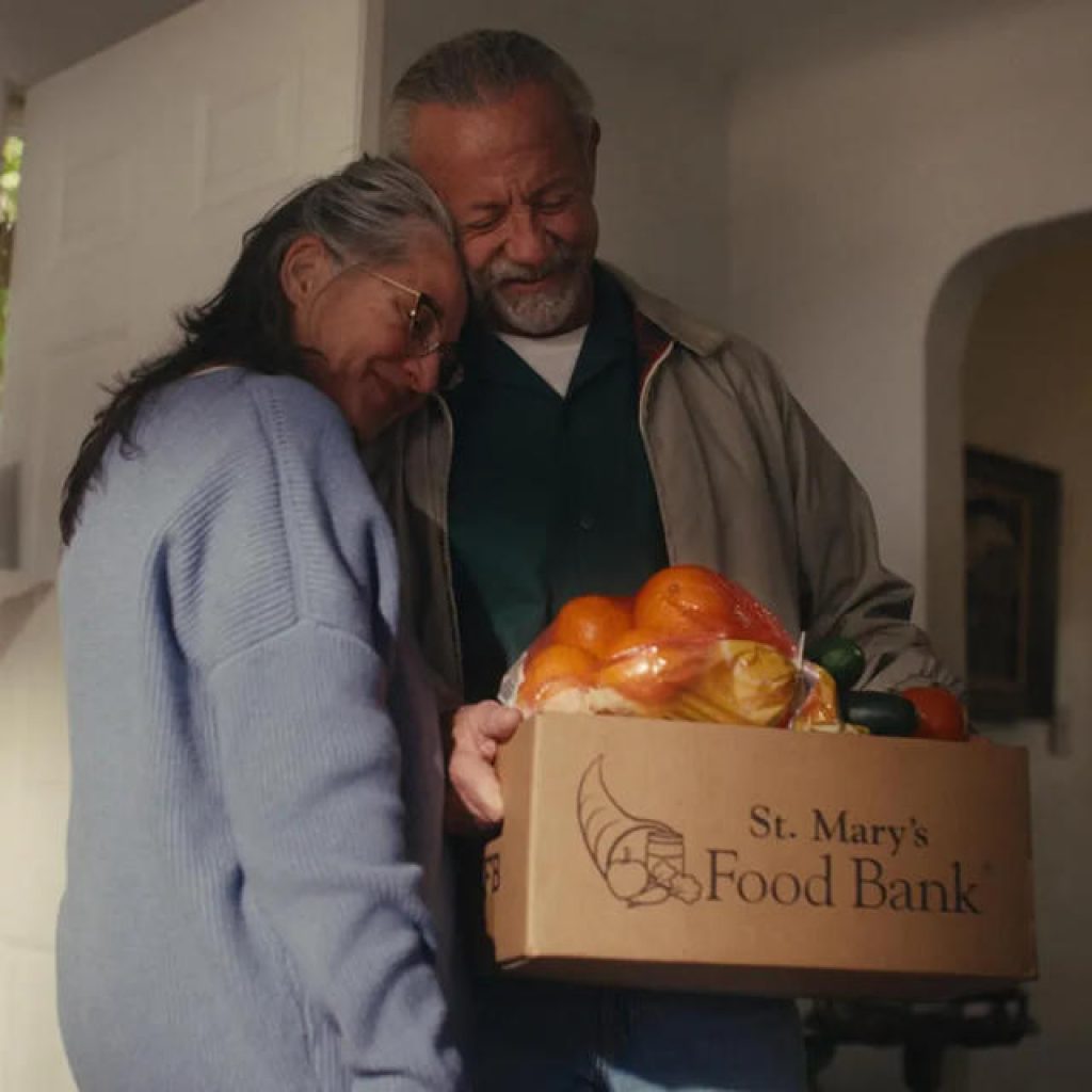 Couple holding groceries box
